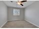 Clean bedroom with a ceiling fan, neutral walls, a large window, and soft carpet at 5484 Mercury Springs Dr, Las Vegas, NV 89122