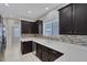 Bright kitchen featuring white countertops, backsplash, and dark cabinets at 5484 Mercury Springs Dr, Las Vegas, NV 89122