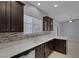 Modern kitchen with dark cabinets, white countertops, and stainless steel dishwasher at 5484 Mercury Springs Dr, Las Vegas, NV 89122