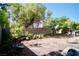 Large backyard with stone patio, trees, and block wall for privacy at 6131 Pumpkin Patch Ave, Las Vegas, NV 89142