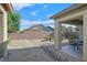 The backyard features desert landscaping, rock ground cover, shrubbery, a patio, and a brick privacy wall at 6141 Tokara Ave, Las Vegas, NV 89122