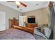 Comfortable bedroom features a ceiling fan, TV, armchair, and wood dresser at 6141 Tokara Ave, Las Vegas, NV 89122