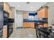 Bright eat-in kitchen boasting light wood cabinets and black appliances at 6141 Tokara Ave, Las Vegas, NV 89122