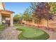 Lush backyard featuring a putting green, decorative gravel, and mature shade trees at 6233 Canterbury Field Rd, Las Vegas, NV 89113