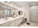 Bathroom featuring double sinks, vanity and large mirror, plus a shower and soaking tub behind the window at 6233 Canterbury Field Rd, Las Vegas, NV 89113
