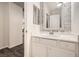 Clean bathroom featuring a vanity with dual mirrors and sinks, white cabinets, and decorative wall accents at 6233 Canterbury Field Rd, Las Vegas, NV 89113