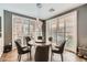 Bright dining room with modern chandelier, dark wood table and chairs, with natural light, and wood floors at 6233 Canterbury Field Rd, Las Vegas, NV 89113