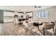 Bright, open concept living room and kitchen, featuring hardwood floors, white cabinets, and modern furnishings at 6233 Canterbury Field Rd, Las Vegas, NV 89113
