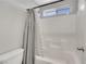 Bright bathroom features a tub with white tile and a modern gray patterned shower curtain at 6678 Crystal Run Ln, Las Vegas, NV 89122