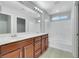 Bathroom with double vanity, bathtub, and separate mirror with cabinet view at 6678 Crystal Run Ln, Las Vegas, NV 89122