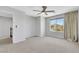 Large carpeted bedroom with ceiling fan and window, offering space and comfort at 6678 Crystal Run Ln, Las Vegas, NV 89122