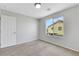 A carpeted bedroom features a bright window with a view of the neighborhood at 6678 Crystal Run Ln, Las Vegas, NV 89122