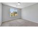A carpeted bedroom features a bright window with a view of the neighborhood at 6678 Crystal Run Ln, Las Vegas, NV 89122