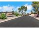 View of the neighborhood street featuring desert landscaping and wrought iron gates at 6678 Crystal Run Ln, Las Vegas, NV 89122