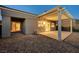 Backyard view with a covered patio, desert landscaping, and sliding glass doors leading indoors at 713 Chase Tree St, Las Vegas, NV 89144
