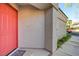 Close-up of a modern exterior showcasing a vibrant red front door and neutral stucco siding at 713 Chase Tree St, Las Vegas, NV 89144
