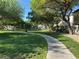 Serene community park with lush green space, walking path, mature trees, and seating areas at 7226 Freedom Ring St, Las Vegas, NV 89148