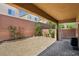 The backyard features gravel landscaping, with a covered patio area extending the living space outdoors for relaxation and enjoyment at 7407 Bakewell Ave, Las Vegas, NV 89179