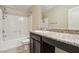 Bright bathroom featuring a tub with shower, granite counters, and stylish cabinetry at 7407 Bakewell Ave, Las Vegas, NV 89179