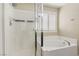Bright bathroom with a glass-enclosed shower, soaking tub, and plantation shutters at 7407 Bakewell Ave, Las Vegas, NV 89179