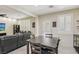 View of the dining area with a wooden table, chairs, and modern decor, seamlessly connecting to the living room at 7407 Bakewell Ave, Las Vegas, NV 89179