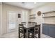 Bright dining area with a wooden table, chairs, shelving and view of the door leading to the exterior at 7407 Bakewell Ave, Las Vegas, NV 89179
