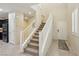 Bright entryway with tiled floor, leading to carpeted stairs and featuring a white front door and shuttered window at 7407 Bakewell Ave, Las Vegas, NV 89179