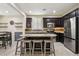 Modern kitchen with a large island, stainless steel appliances, granite countertops, and dark wood cabinets at 7407 Bakewell Ave, Las Vegas, NV 89179
