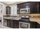Stylish kitchen featuring stainless steel appliances, granite countertops, and dark wood cabinetry for a modern aesthetic at 7407 Bakewell Ave, Las Vegas, NV 89179