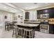 Spacious kitchen with a large island, granite countertops, stainless steel appliances, and an adjacent dining area at 7407 Bakewell Ave, Las Vegas, NV 89179
