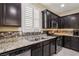 Modern kitchen with granite counters, backsplash, stainless steel appliances and ample cabinet space at 7407 Bakewell Ave, Las Vegas, NV 89179