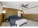 Comfortable main bedroom featuring carpet, a ceiling fan, and a bench at the end of the bed at 7407 Bakewell Ave, Las Vegas, NV 89179