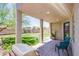 Covered back patio with seating overlooking a grass yard and fire pit area at 7445 Mezzanine View Ave, Las Vegas, NV 89178
