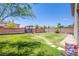 Large backyard featuring a fire pit area, desert landscaping, and a grass yard at 7445 Mezzanine View Ave, Las Vegas, NV 89178