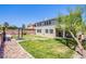 Backyard view showing house exterior, grass yard, fire pit area, and desert landscaping at 7445 Mezzanine View Ave, Las Vegas, NV 89178