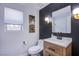 Modern powder room with a stylish vanity, black accent wall, and framed artwork at 7445 Mezzanine View Ave, Las Vegas, NV 89178