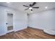 Empty bedroom with rich hardwood flooring, fan, walk-in closet and dog bed at 7445 Mezzanine View Ave, Las Vegas, NV 89178