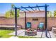 Outdoor fire pit with seating set on pavers in landscaped backyard at 7445 Mezzanine View Ave, Las Vegas, NV 89178