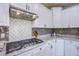 Up close view of kitchen details including gas cooktop and white tiled backsplash at 7445 Mezzanine View Ave, Las Vegas, NV 89178