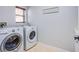 Bright laundry room with tile floor and modern front-loading washer and dryer at 7445 Mezzanine View Ave, Las Vegas, NV 89178