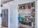 Walk-in pantry with lots of shelving for storage with stainless refrigerator to the left at 7445 Mezzanine View Ave, Las Vegas, NV 89178