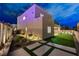 Exterior of modern house featuring landscaped side yard, patio, artificial turf and ample outdoor space at twilight at 746 Horizon Canyon Dr, Henderson, NV 89052