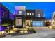 A modern two-story home with eye-catching curb appeal features a desert landscape and statement garage door at 746 Horizon Canyon Dr, Henderson, NV 89052
