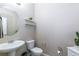Well-lit half bathroom with pedestal sink, round mirror, and decorative shelving at 7652 Silver Baron Rd, Las Vegas, NV 89179