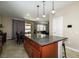 Kitchen island with dark wood cabinets, granite countertops, and pendant lighting above at 7652 Silver Baron Rd, Las Vegas, NV 89179
