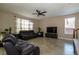Cozy living room with leather furniture, neutral walls, tile floors and a ceiling fan at 7652 Silver Baron Rd, Las Vegas, NV 89179