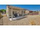 Private backyard featuring a covered patio, rock landscape, and a metal fence at 7717 Pine Warbler Way, North Las Vegas, NV 89084