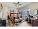 Bright bedroom featuring wood floors, a ceiling fan, and a large window with natural light at 7717 Pine Warbler Way, North Las Vegas, NV 89084