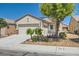 Inviting single-story home with desert landscaping, a two-car garage, and a quaint front porch at 7717 Pine Warbler Way, North Las Vegas, NV 89084
