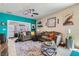 Comfortable living room with stylish decor, including a colorful rug, decorative shelves, and a modern ceiling fan at 7717 Pine Warbler Way, North Las Vegas, NV 89084